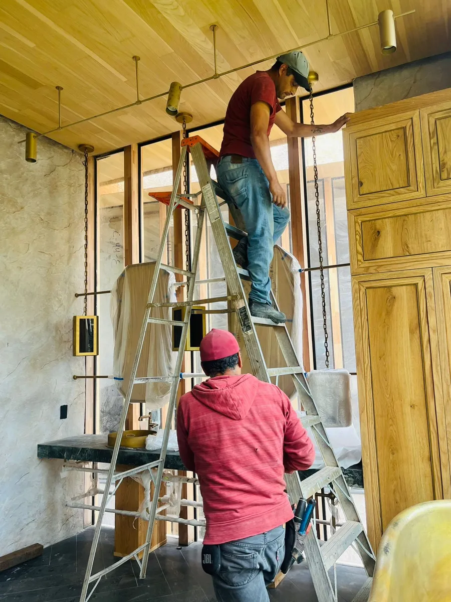 Instaladores montando lavabos suspendidos y gabinetes de encino